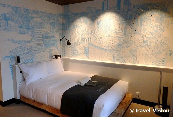 「スタンダード+バルコニー」は、20平方メートルの部屋と5平方メートルのバルコニーで構成。ベッド横の壁には渋谷の景色が描かれている