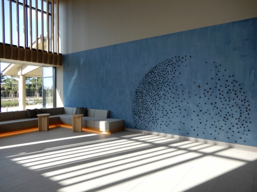フロントの壁を飾るのは、伝統の「たたら製鉄」を受け継ぐ技法で生み出される玉鋼とノロという素材。日本海に沈む夕日がモチーフ