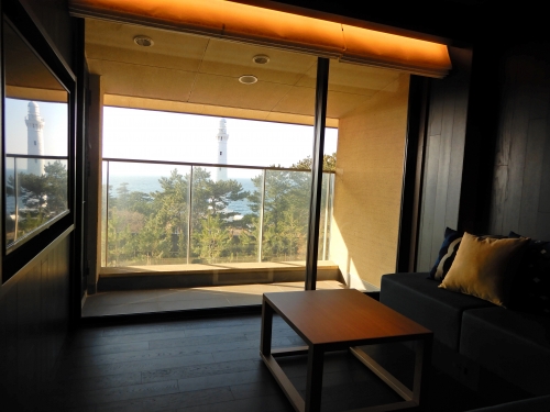 出雲松島の海の眺めの客室と日御埼灯台を望む客室の2タイプを用意。こちらは灯台ビューで夕日のオレンジが鮮やかに見えるように藍色のリビングカラー